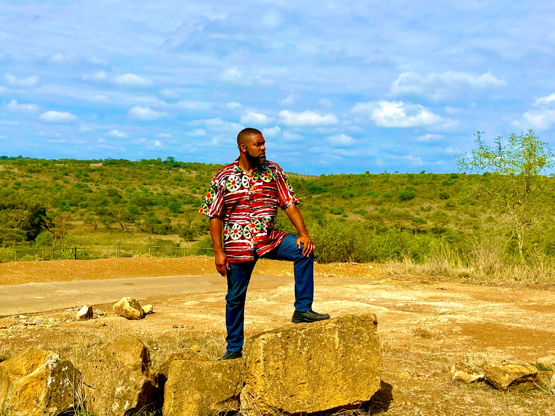 Jay Cameron standing on rocks overlooking open savanna